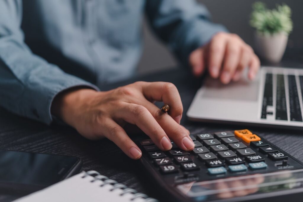 man using calculator at desk