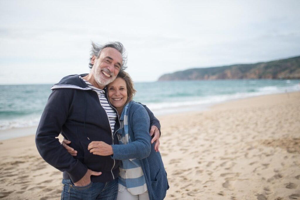 middle aged couple smiling on the beach