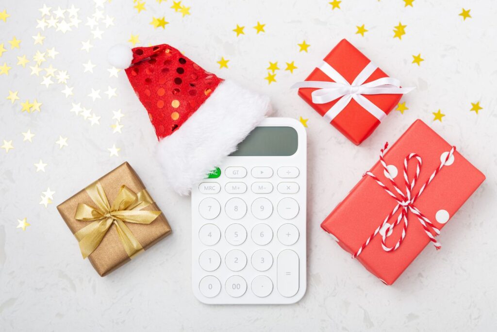 A calculator with a christmas hat and gifts