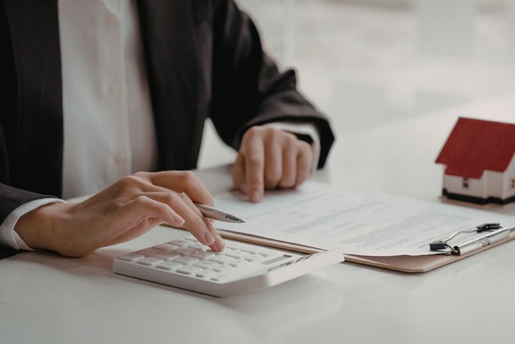 Calculating mortgage payments with calculator and documents