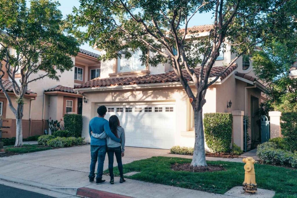 Couple Standing In Front of their House