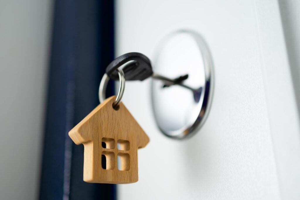 Key In Door Lock With Wooden House Real Estate Concept