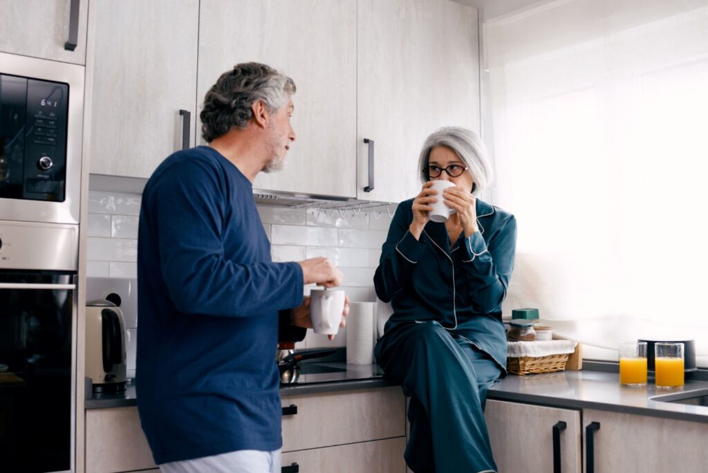 Senior couple enjoying morning coffee and conversation in kitchen